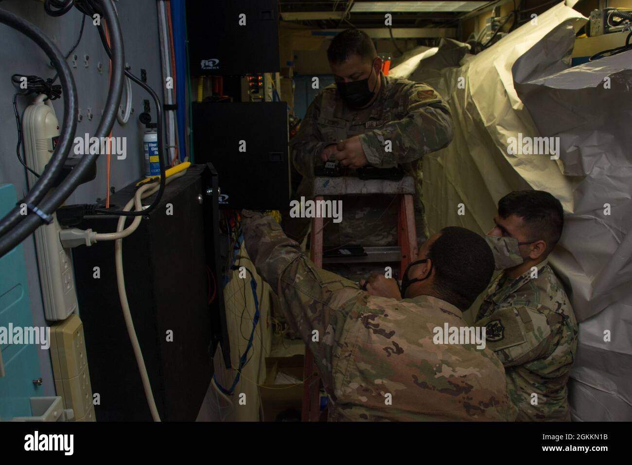 RIVERSIDE, California, (18 maggio 2021) U.S. Air Force Tech. SGT. Javiel Ladines (TOP), il personale dell'aeronautica statunitense Sgt. Adrian Scott (a sinistra) e U.S. Army Sgt. Prima classe Adam Lozano (a destra), Defense Media Activity Riverside (DMA-R), Television-Audio Support Activity (T-ASA) preparare il cavo in fibra ottica per l'installazione per un aggiornamento della rete DMA-R. T-ASA fornisce un'ampia gamma di supporto per la progettazione di Visual Information al DoD. Foto Stock