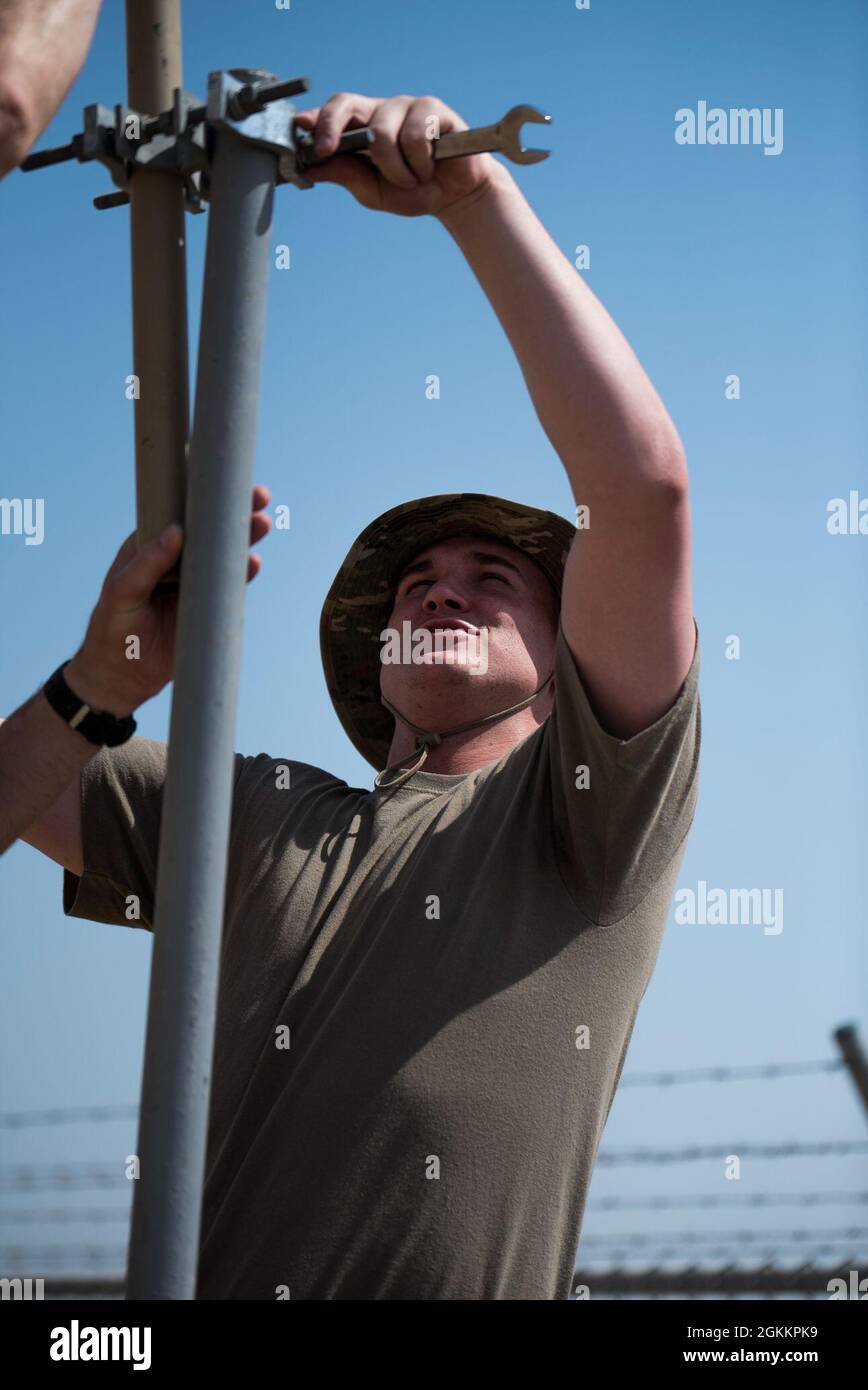 U.S. Air Force Airman 1st Class Joseph Eckerman, 380th Expeditionary Communications Squadron radio frequency transmission Technician, installa le stazioni base e le antenne alla base aerea al Dhafra, Emirati Arabi Uniti, 20 maggio 2021. L'installazione migliorerà la capacità dei manutentori di comunicare lungo la linea di volo. Foto Stock
