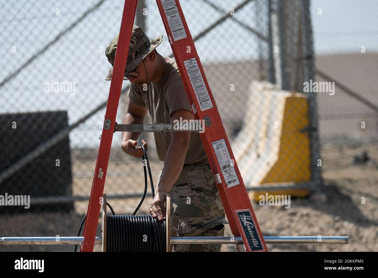 U.S. Air Force Airman 1st Class Andrei Ludovice, 380th Expeditionary Communications Squadron radio frequency transmission Technician, installa stazioni base e antenne presso la base aerea al Dhafra, Emirati Arabi Uniti, 20 maggio 2021. L'installazione migliorerà la capacità dei manutentori di comunicare lungo la linea di volo. Foto Stock