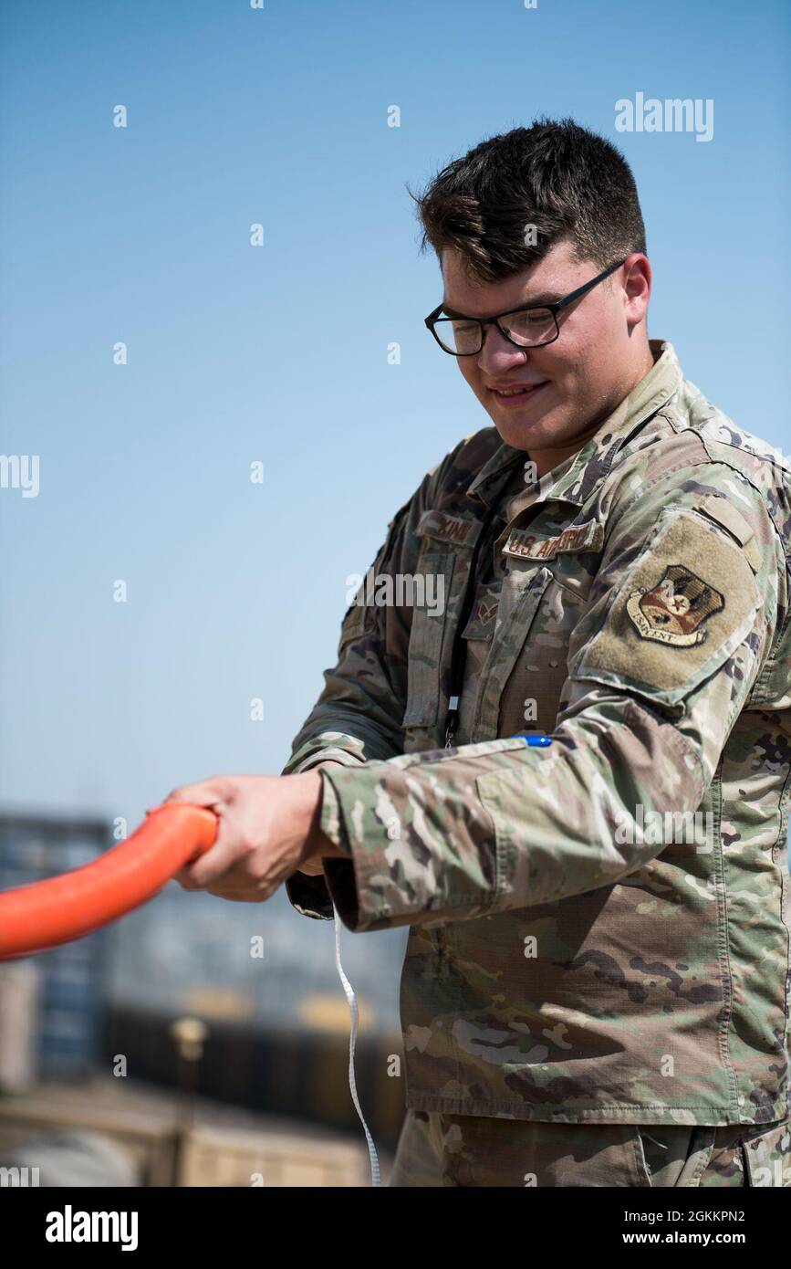 U.S. Air Force Senior Airman Dakota King, 380th Expeditionary Communications Squadron radio frequency transmission Technician, stende internal-dotto durante l'installazione di stazioni base e antenne presso la base aerea al Dhafra, Emirati Arabi Uniti, 20 maggio 2021. L'installazione migliorerà la capacità dei manutentori di comunicare lungo la linea di volo. Foto Stock