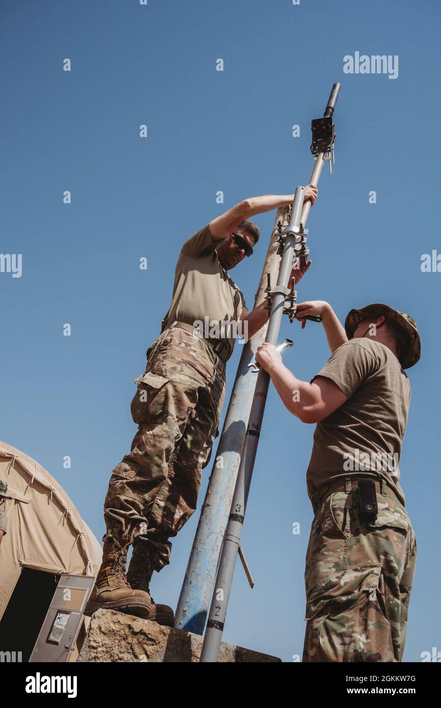 U.S. Air Force Tech. SGT. Bart Simon e Airman 1st Class Joseph Eckerman, 380th Expeditionary Communications Squadron radio frequency transmission tecnici, installare stazioni base e antenne alla base aerea al Dhafra, Emirati Arabi Uniti, 20 maggio 2021. L'installazione migliorerà la capacità dei manutentori di comunicare lungo la linea di volo. Foto Stock