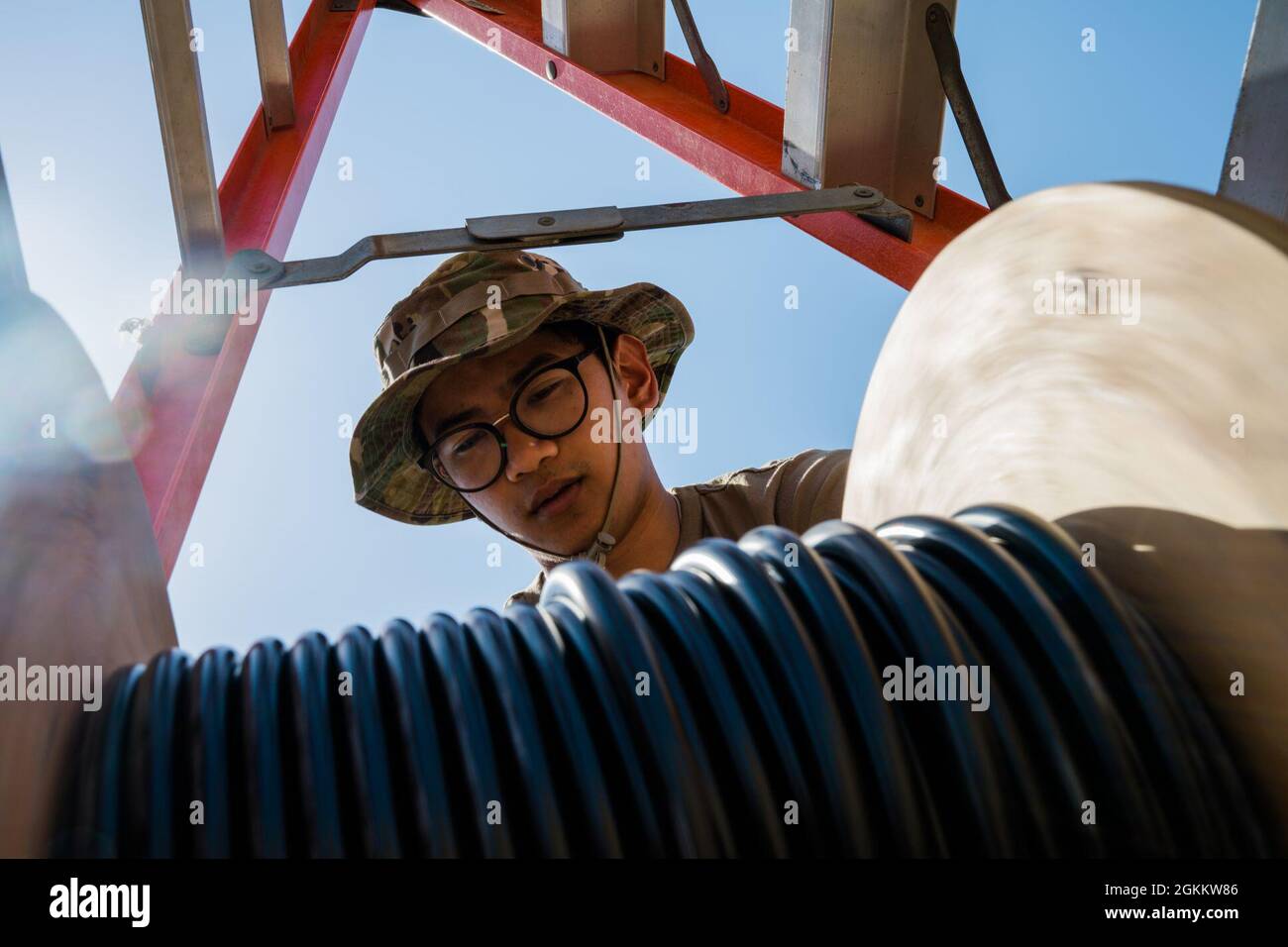 U.S. Air Force Airman 1st Class Andrei Ludovice, 380th Expeditionary Communications Squadron radio frequency transmission Technician, installa stazioni base e antenne presso la base aerea al Dhafra, Emirati Arabi Uniti, 20 maggio 2021. L'installazione migliorerà la capacità dei manutentori di comunicare lungo la linea di volo. Foto Stock
