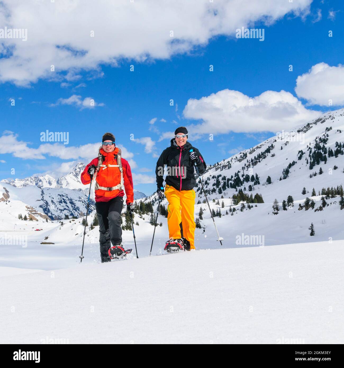 Coppia giovane escursionismo con le racchette da neve in una bella giornata nel tardo inverno Foto Stock