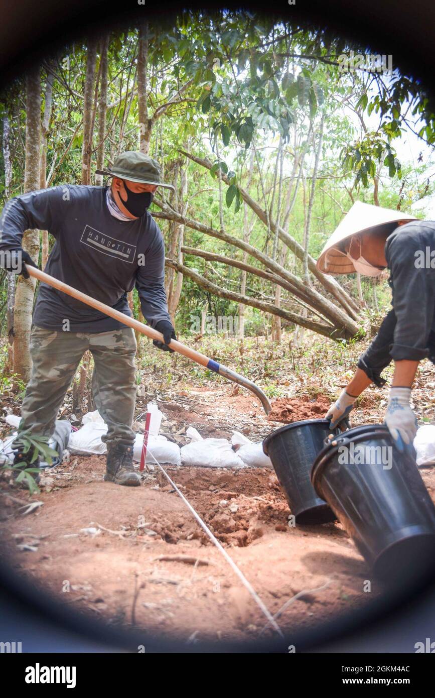 Jason Nguyen, un esperto di comunicazione della Defense POW/mia Accounting Agency (DPAA), spacca lo sporco in un secchio da sottoporre a screening per potenziali relitti aerei e prove provenienti da un sito di scavo nella Repubblica democratica popolare del Laos, 21 maggio 2021. Il team di recupero due ha eseguito operazioni di scavo alla ricerca di due piloti dell'aeronautica americana mancanti che si sono schiantati durante una missione di controllo aereo in avanti durante la guerra del Vietnam. La missione di DPAA è quella di ottenere il più possibile la contabilità per il personale degli Stati Uniti mancante e non contabilizzato per le loro famiglie e la nostra nazione. Foto Stock