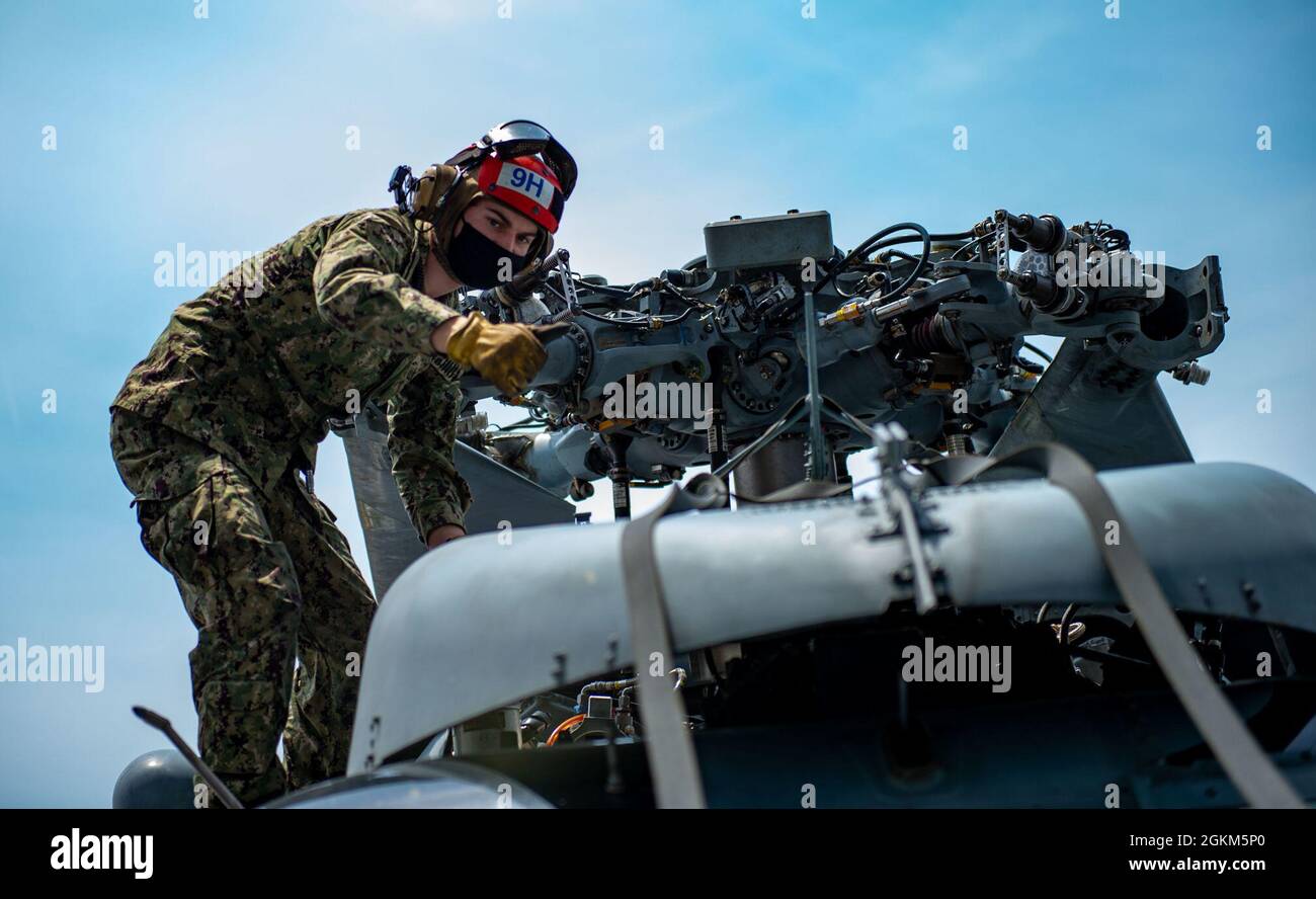 210522-N-NV699-1014 OCEANO ATLANTICO (22 maggio 2021) Airman Shane Gilson, di Paulden, Arizona, segnala un controllo soddisfacente durante l'ispezione dei rotori di un elicottero MH-60 Sea Hawk, attaccato al 'dragon Slayers' di Helicopter Sea Combat Squadron (HSC) 11, Sul ponte di volo del vettore aereo di classe Nimitz USS Harry S. Truman (CVN 75) durante le prove in mare dopo aver completato una disponibilità incrementale estesa del vettore. Le prove in mare comprendono un test completo dei sistemi e delle tecnologie della nave per garantire che la nave sia pronta a riprendere le operazioni. Foto Stock