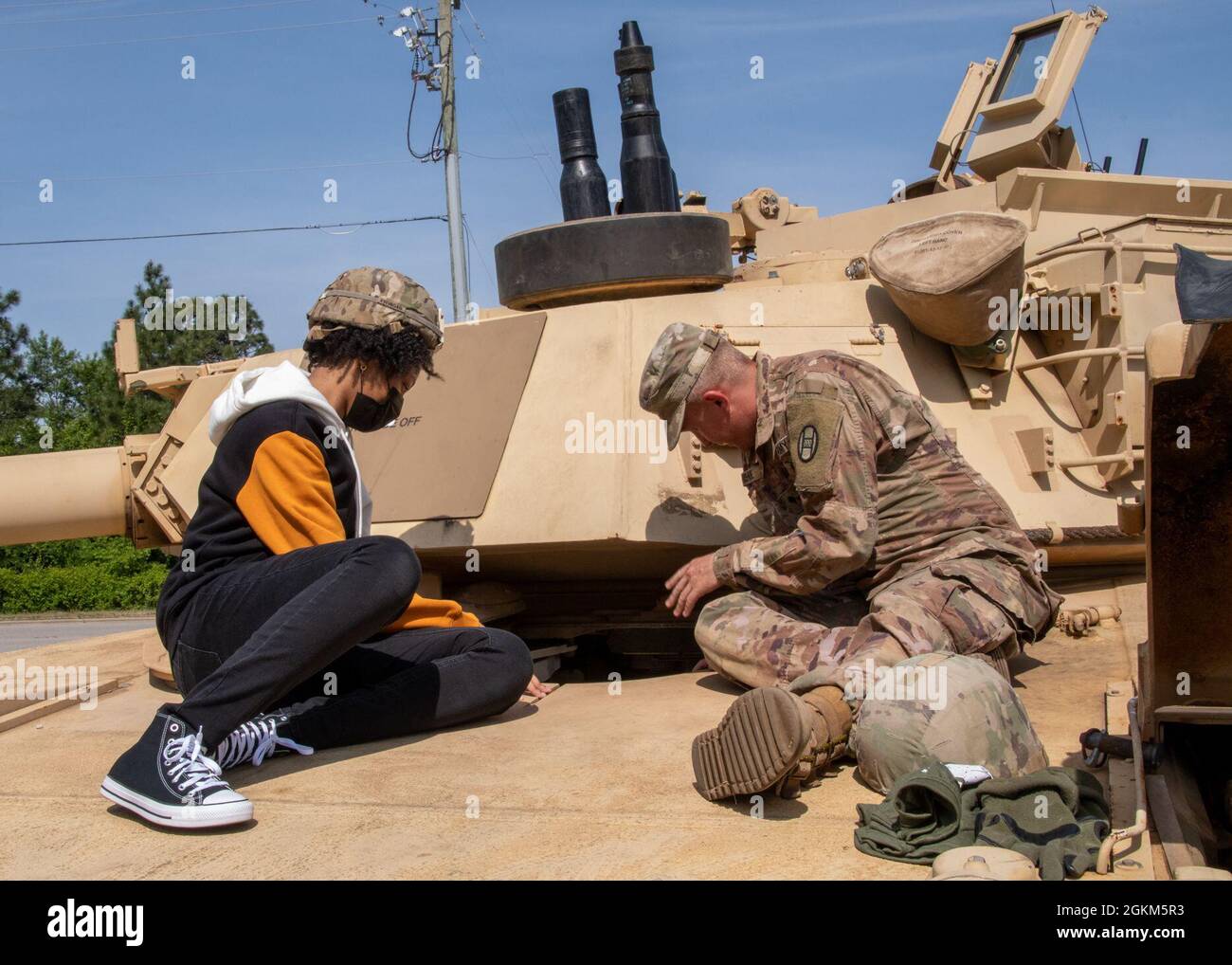 Un soldato assegnato al 1 ° Battaglione, 252nd Armour Regiment, 30th Armored Brigade Combat Team, parla di un carro armato M1 Abrams ad un potenziale reclutamento durante una esperienza della Guardia Nazionale dell'Esercito del Nord Carolina presso la Guardia Nazionale Armory a Fayetteville, Carolina del Nord, 22 maggio 2021. Circa 30 ospiti e potenziali reclute hanno imparato a conoscere i veicoli da combattimento, le operazioni di paracadute, i sistemi di armi individuali, il test di idoneità di combattimento dell'esercito, le opportunità di carriera medica sul campo e i benefici di essere un NC Guard Soldier. Il NCARNG è un team sempre pronto e pronto di soldati cittadini con op disponibile Foto Stock