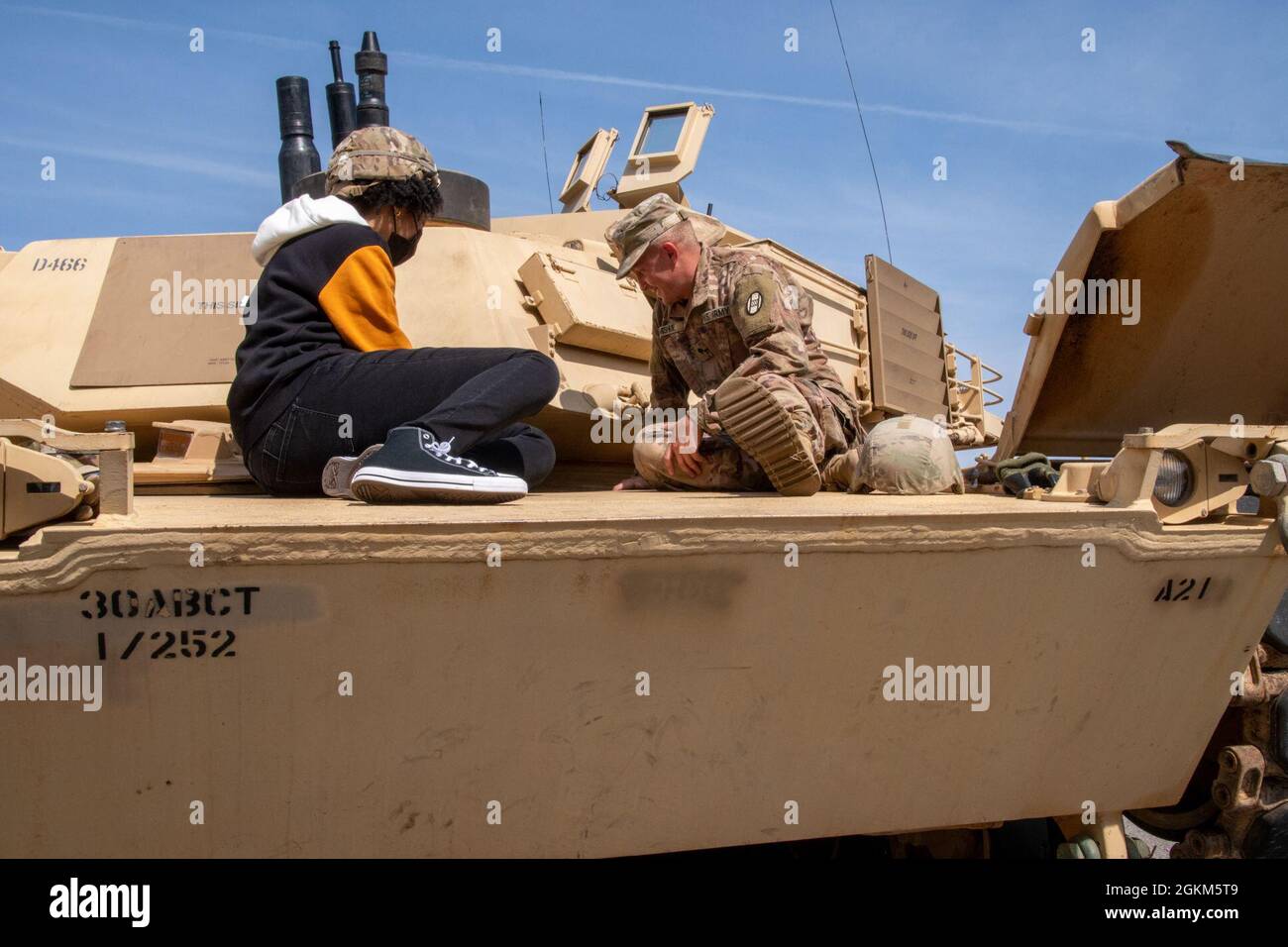 SPC. David Mishue, un equipaggio M1 assegnato alla Bravo Company, 1° Battaglione, 252o reggimento armatura, 30o Armored Brigade Combat Team, parla di un potenziale reclutamento sul carro armato M1 Abrams durante un'esperienza della Guardia Nazionale dell'Esercito del North Carolina presso la Guardia Nazionale di Fayetteville, Carolina del Nord, 22 maggio 2021. Circa 30 ospiti e potenziali reclute hanno imparato a conoscere i veicoli da combattimento, le operazioni di paracadute, i sistemi di armi individuali, il test di idoneità di combattimento dell'esercito, le opportunità di carriera medica sul campo e i benefici di essere un NC Guard Soldier. Il NCARNG è una T sempre pronta, pronta Foto Stock