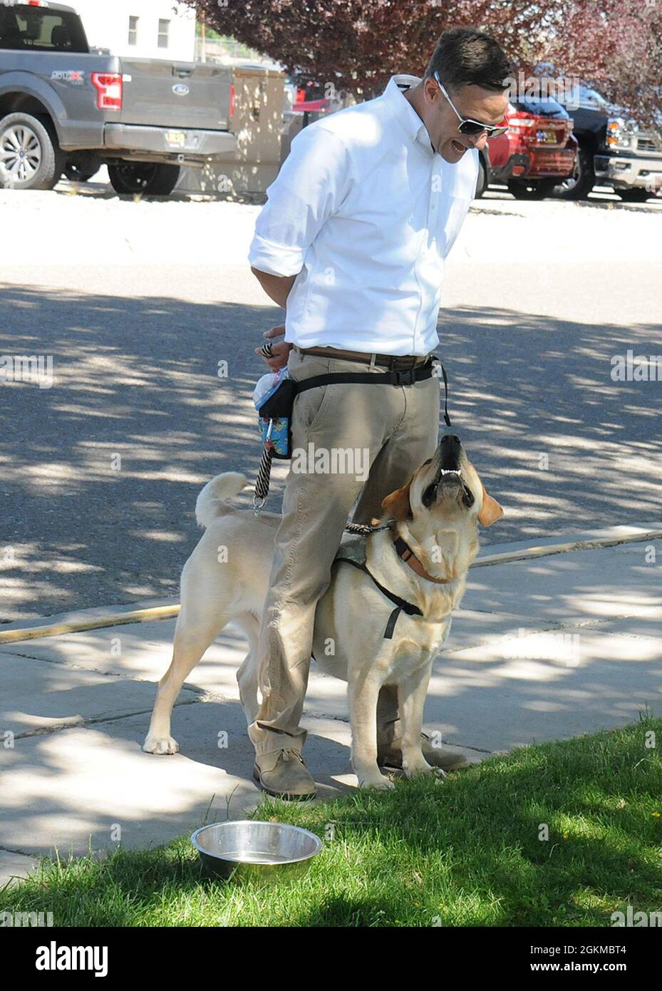 Ari Jontry, veterani di collegamento/istruttore/formatore con i cani di assistenza dell'ovest, interagisce con il cane di servizio Cedar durante un evento educativo per i funzionari di alloggiamento alla base dell'aeronautica di Kirtland, New Mexico, 25 maggio 2021. Foto Stock