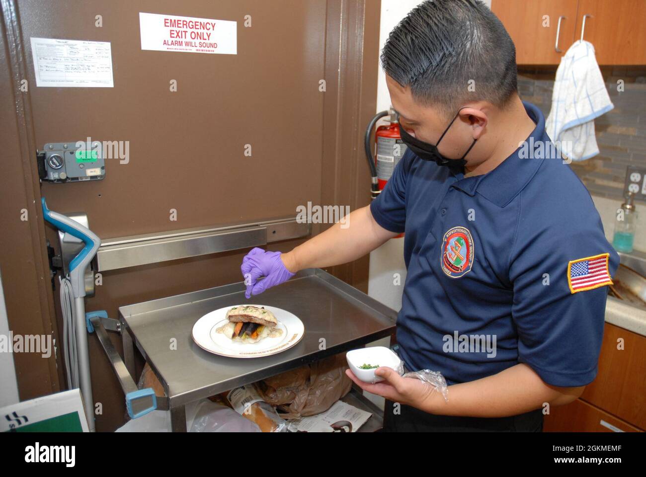 Specialista culinario 1st Class Alan Yang prepara un piatto per il pranzo di riconoscimento 2020 del marinaio dell'anno presso la sede di Expeditionary Strike Group (ESG) 3, maggio 26. Ospedale Corpsman 1a classe Christian Lopez, assegnato alla nave d'assalto anfibio USS Essex (LHD 2), è stato riconosciuto come ESG 3, Anfibio Squadron (PHIBRON) 1, e Essex 2020 Sailor of the Year. Foto Stock