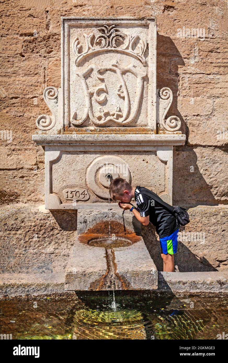 Bere da una fontana, datata 1504, sulla parete di fondo della Chiesa dell'Incarnatazione in Alhama de Granada, provincia di Granada, Andalusia, Spagna Foto Stock