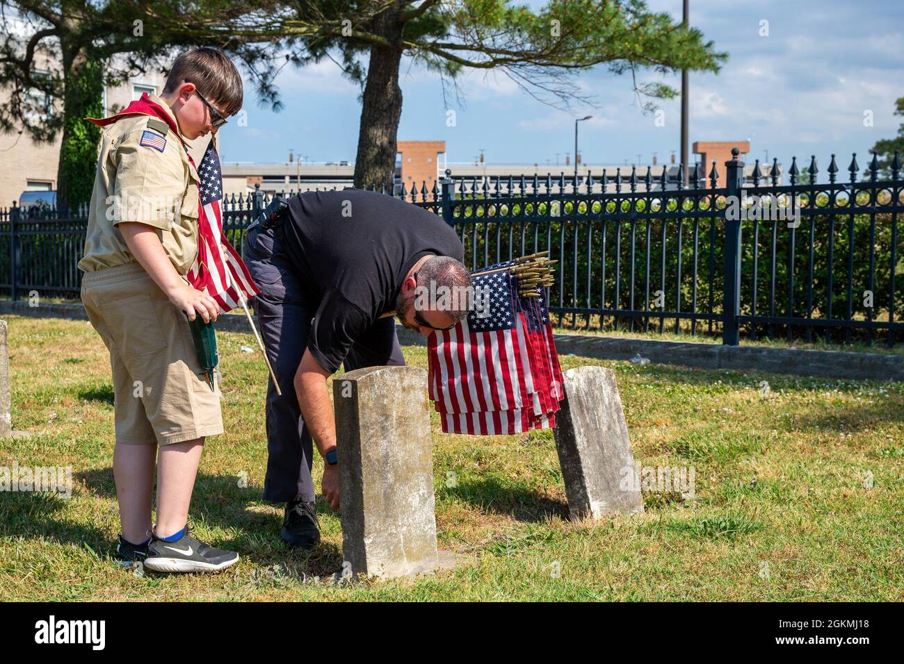 Nicholas Boyle e suo figlio Connor Boyle Place bandierine sulle tombe dei membri caduti durante la cerimonia annuale di stallonamento della bandiera al cimitero navale di Captain Ted Conaway Memorial nel Naval Medical Center Portsmouth (NMCP) maggio 27. Foto Stock