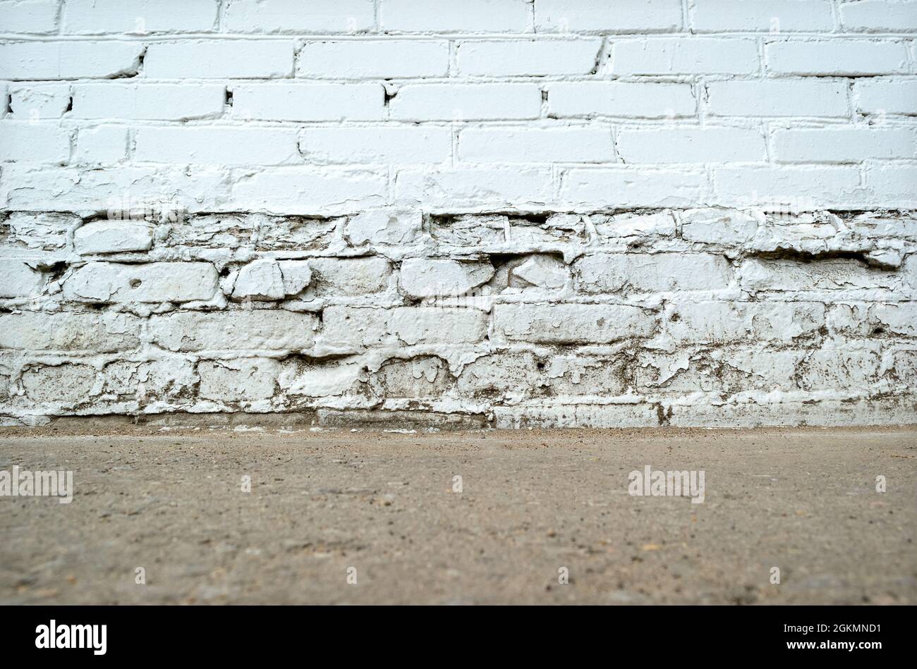 Vuoto bianco mattone invecchiato parete sporca con piano terra Foto Stock