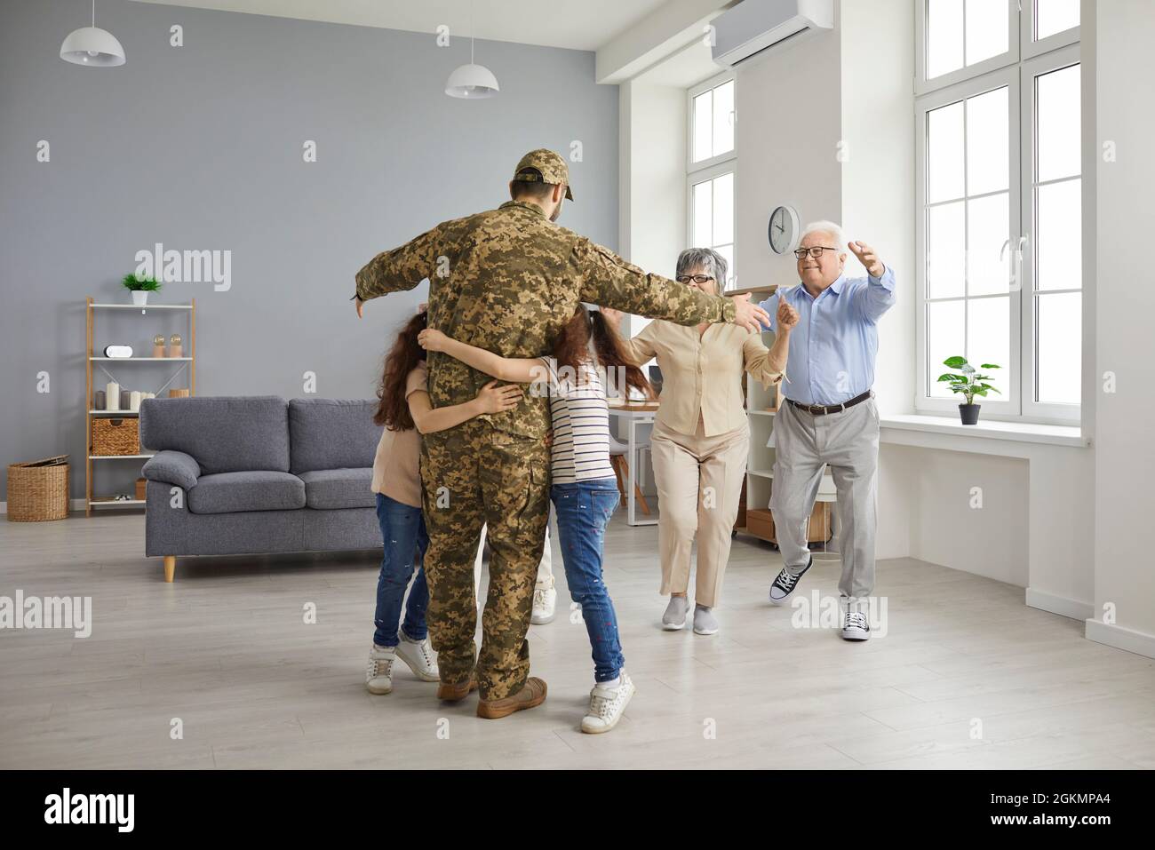 La famiglia è felice di vedere un soldato veterano che è tornato a casa dal servizio militare Foto Stock