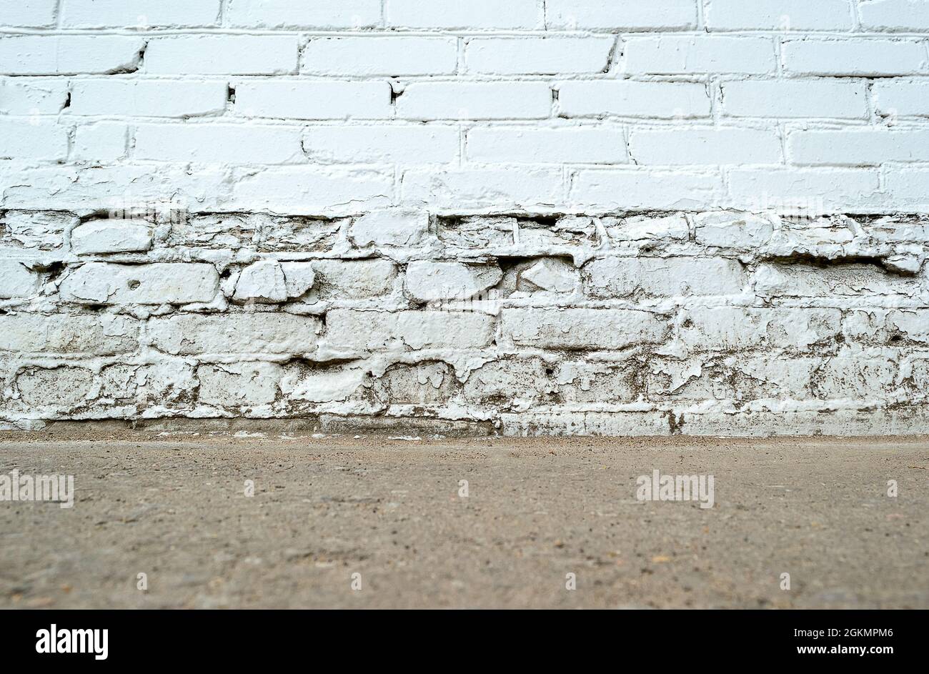 Vuoto bianco mattone invecchiato parete sporca con piano terra Foto Stock