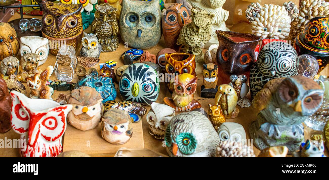 un'ampia selezione di gufi in miniatura in ceramica, vetro in diverse forme, colori e dipinti al mercato delle pulci Foto Stock