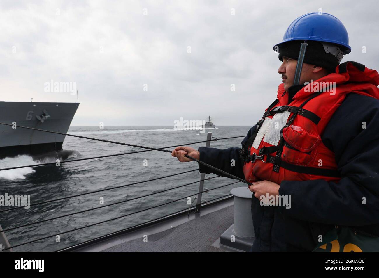 MARE DEL NORD (31 maggio 2021) Sonar Technician (Surface) terza classe Jonathan Salas, assegnato al cacciatorpediniere missilistico guidato di classe Arleigh Burke USS Ross (DDG 71), tiene una linea telefonica e a distanza durante un rifornimento in mare con la nave di supporto rapido al combattimento USNS Supply (T-AOE 6), a sinistra, Mentre il cacciatorpediniere missilistico guidato di classe Arleigh Burke USS Roosevelt (DDG 80), al centro, si stacca dal lato sinistro di Supply, il 31 maggio 2021. Ross e Roosevelt partecipano all'esercizio di at-Sea Demo/formidabile Shield, condotto dalle forze Navali di attacco e supporto NATO per conto della Sesta flotta degli Stati Uniti, un'integra Live-Fire Foto Stock