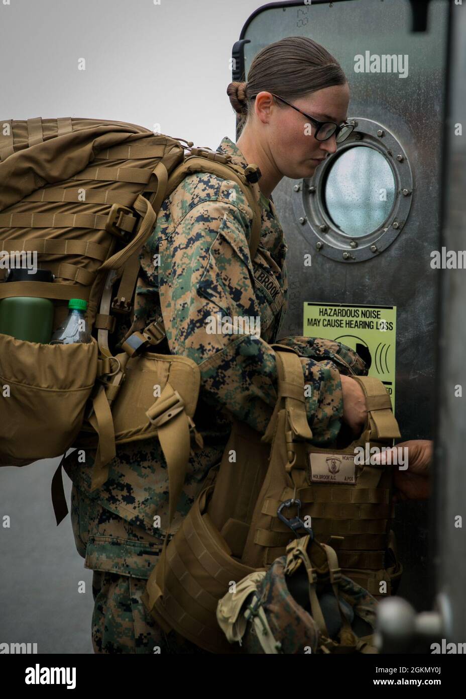US Marine Corps Lance CPL. Alayna Holbrook, specialista del supporto all'atterraggio con 3d Landing Support Battalion, 3d Marine Logistics Group (MLG), carica il suo equipaggiamento in un Landing Craft Air Cushion (LCAC) sulla base navale di White Beach, Okinawa, Giappone, 1° giugno 2021. Marines di 3d MLG e marinai di Naval Beach Unit 7 integrati per il carico e il trasporto di personale e attrezzature a supporto della torre di osservazione Poseidon esercizio. NBU-7 è un'unità operativa, schierata in avanti che contribuisce direttamente alle capacità fondamentali del potere marittimo degli Stati Uniti facilitando il movimento delle truppe, delle attrezzature, dei veicoli e. Foto Stock