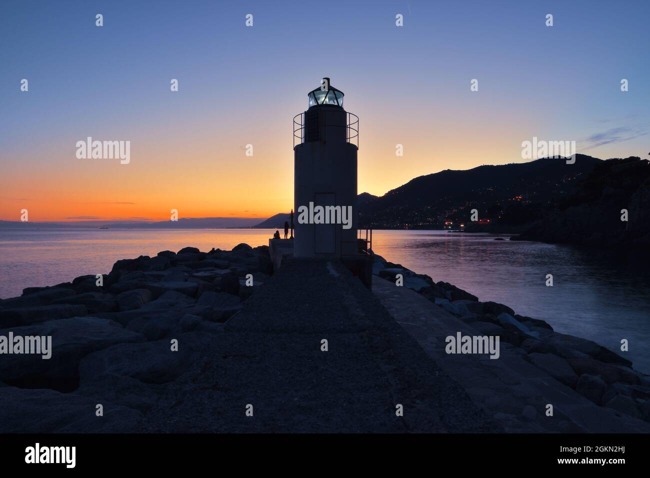 Incantevole tramonto sul mare con vista sul faro di Camogli Foto Stock