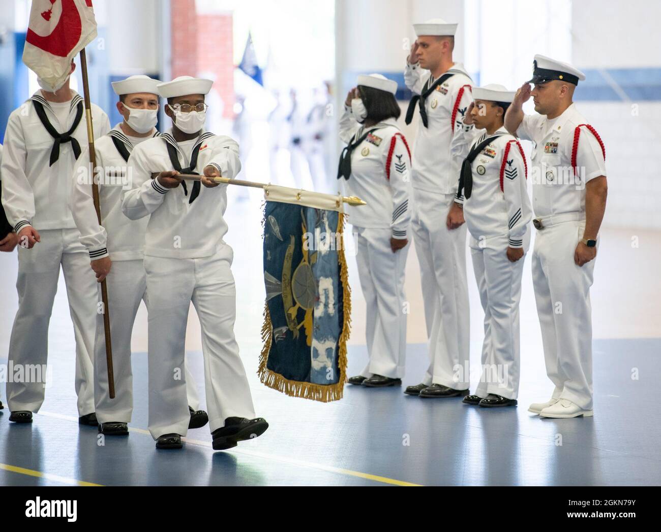 Una guida alle reclute rende un saluto durante una cerimonia di pass-in-review all'interno della Atlantic Fleet Drill Hall al comando di addestramento delle reclute. Più di 40,000 reclute si allenano ogni anno dall'unico campo di stivali della Marina. Foto Stock