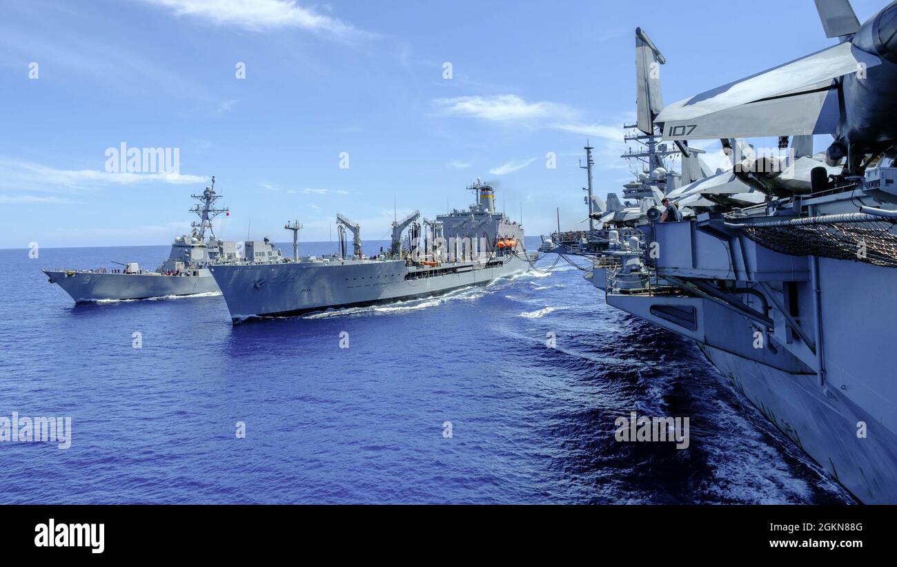 PHILLIPINE SEA (03 giugno 2021) – la compagnia aerea Nimitz-lass USS Ronald Reagan (CVN 76) e il cacciatorpediniere missilistico guidato di classe Arleigh Burke USS HALSEY (DDG 97) conducono un rifornimento simultaneo in mare con l'oliatore di rifornimento in corso di classe Henry J. Kaiser USNS Rappahannock (T-AO-204). Foto Stock