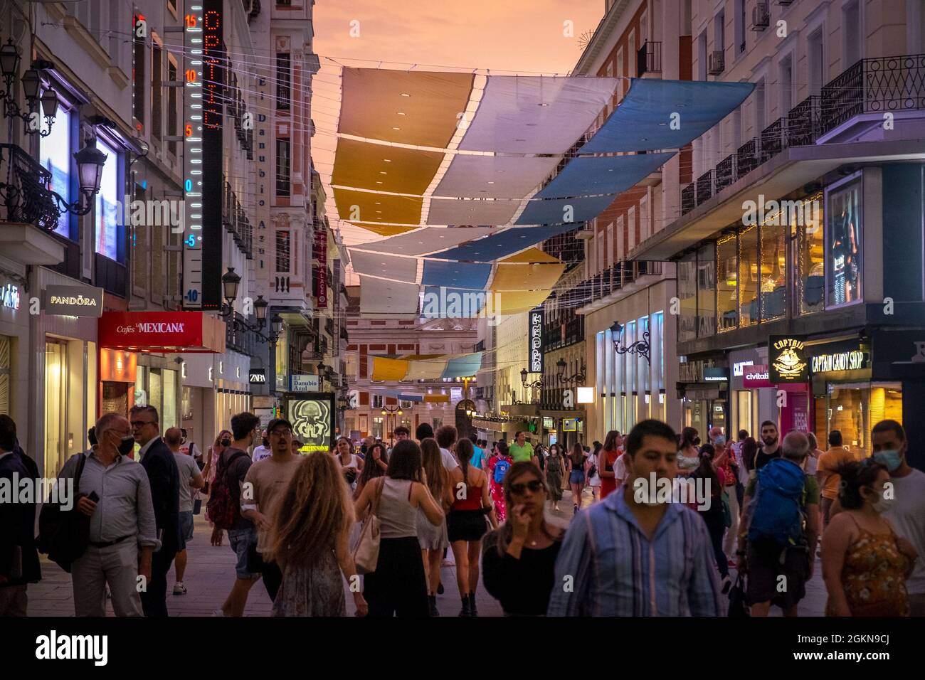 I pedoni attraversano un quartiere commerciale vicino a Puerto del Sol, Madrid, Spagna Foto Stock