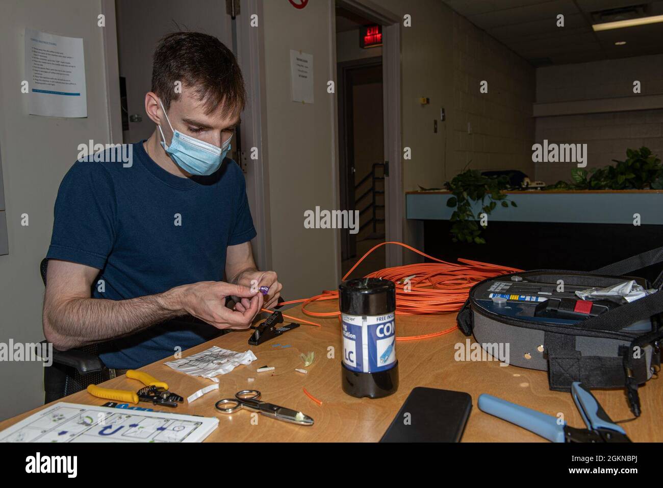 Come 5 Wing, Goose Bay, si prepara per l'esercizio NORAD AMALGAM DART 21-1, Aviator Marc-Antoine Leonard crea i cavi in fibra ottica che saranno utilizzati da postazioni di lavoro per collegarli alla rete di computer dell'esercizio, 4 giugno 2021. Esercizio Amalgam Dart sarà operativo dal 10 al 19 giugno 2021, con operazioni che vanno attraverso l'Artico dal mare di Beaufort a Thule, Groenlandia. Amalgam Dart 21-01 offre a NORAD l'opportunità di affinare le capacità di difesa continentale, mentre le forze canadesi e statunitensi operano insieme nell'Artico. Comando binazionale canadese e americano, NORAD impiega una rete di Foto Stock