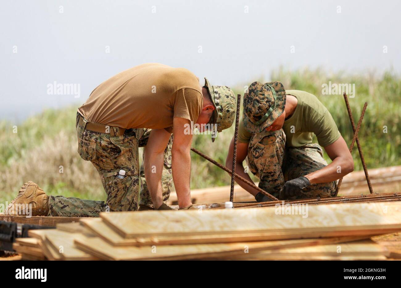 060521-N- RU672-1058 Okinawa, Giappone (5 giugno 2021) costruttore Constructionman James Grant (a sinistra), assegnato a Naval Mobile Construction Battaglione (NMCB) 4, e US Marine Corps CPL. Jason Montalvo (a destra), assegnato al 9° Battaglione di supporto tecnico (ESB), costruisce un telaio di armatura per un sito di costruzione di bunker in calcestruzzo, in una base avanzata di spedizione simulata sul complesso 174 del campo di addestramento di Okinawa, un'isola disabitata al largo della costa di Okinawa, Giappone, come parte dell'esercizio congiunto della torre di avvistamento di Poseidone. Il Watchtower di Poseidon è un esercizio multidominio progettato per simulare il sistema di protezione Foto Stock