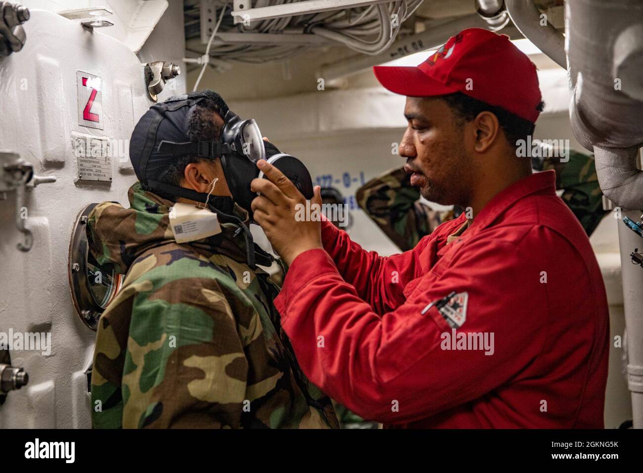OCEANO PACIFICO (5 giugno 2021) – Damage Controlman 2nd Class Kevin Johnson, di Long Beach, California, guida i marinai junior attraverso un ambiente di addestramento General Quarters a bordo del cacciatorpediniere missilistico guidato di classe Arleigh Burke USS Halsey (DDG 97). Halsey è collegata al Comandante, Task Force 70/Carrier Strike Group 5 che svolge operazioni in corso a sostegno di un indoPacifico libero e aperto. Foto Stock