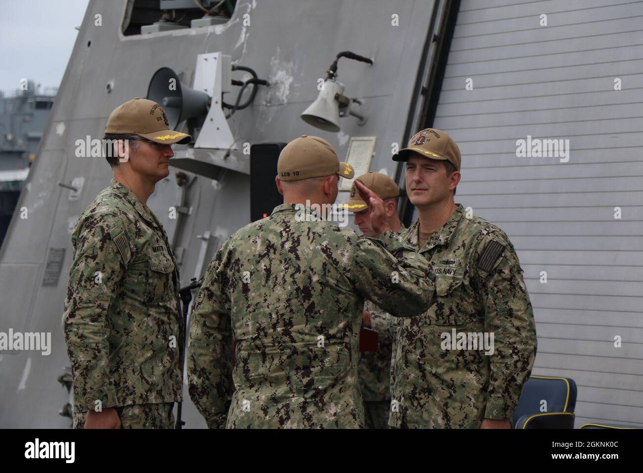 210606-N-N0820-0088 BASE NAVALE SAN DIEGO, California (6 giugno 2021) – CMdR. William Carr, nativo di Bunkie, Louisiana, centro, saluta comandante, Surface Division (COMMURFACEDIV) Eleven, Capt. Marc Crawford, nativo di Fort Wayne, Indiana, destra, come Carr assume il comando della nave da combattimento litoranea variante di indipendenza USS Gabrielle Giffords (LCS 10) Gold Crew durante una cerimonia di cambio comando a bordo della Stazione Navale di San Diego. Durante la cerimonia, Carr ha sollevato il CMdR. William Martin, nativo di Diamond Bar, California, come ufficiale comandante. Foto Stock