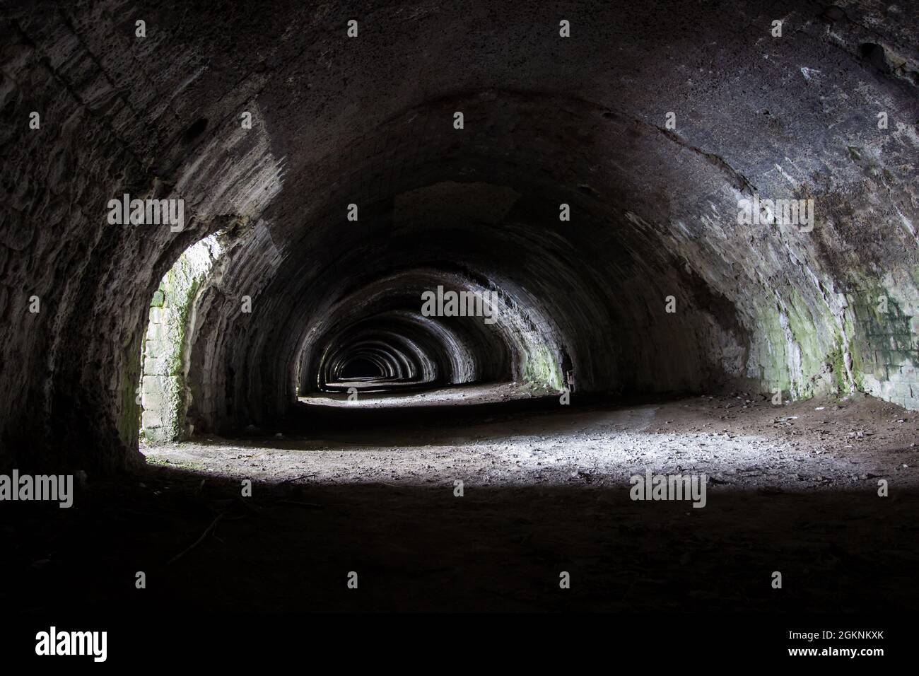 Langcliffe forno di lime in Settle, Yorkshire. Vecchio tunnel in pietra scura con archi e luce interessante Foto Stock