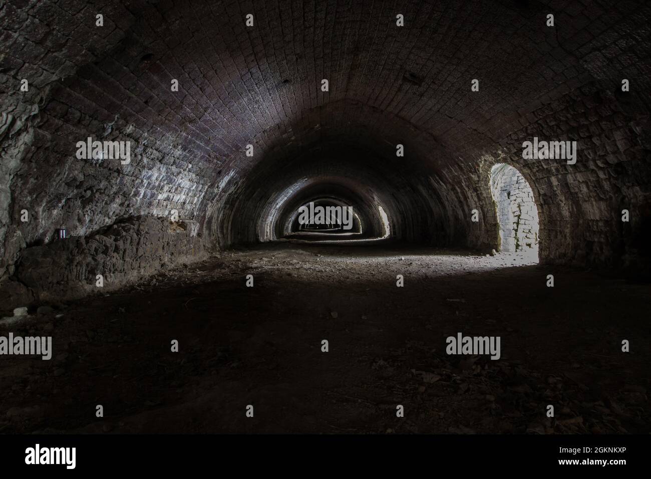 Langcliffe forno di lime in Settle, Yorkshire. Vecchio tunnel in pietra scura con archi e luce interessante Foto Stock