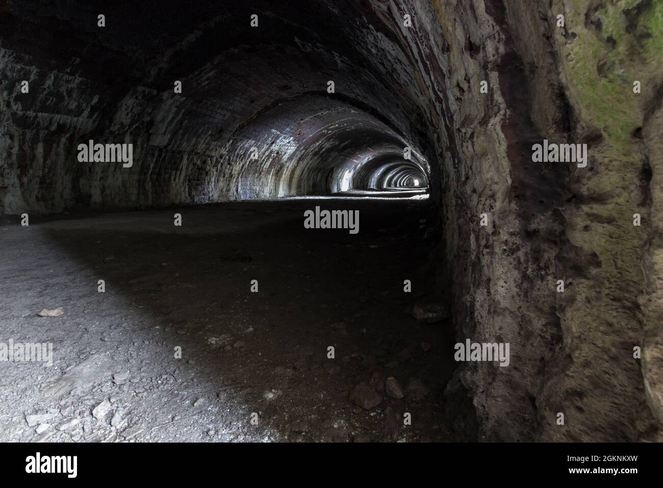 Langcliffe forno di lime in Settle, Yorkshire. Vecchio tunnel in pietra scura con archi e luce interessante Foto Stock