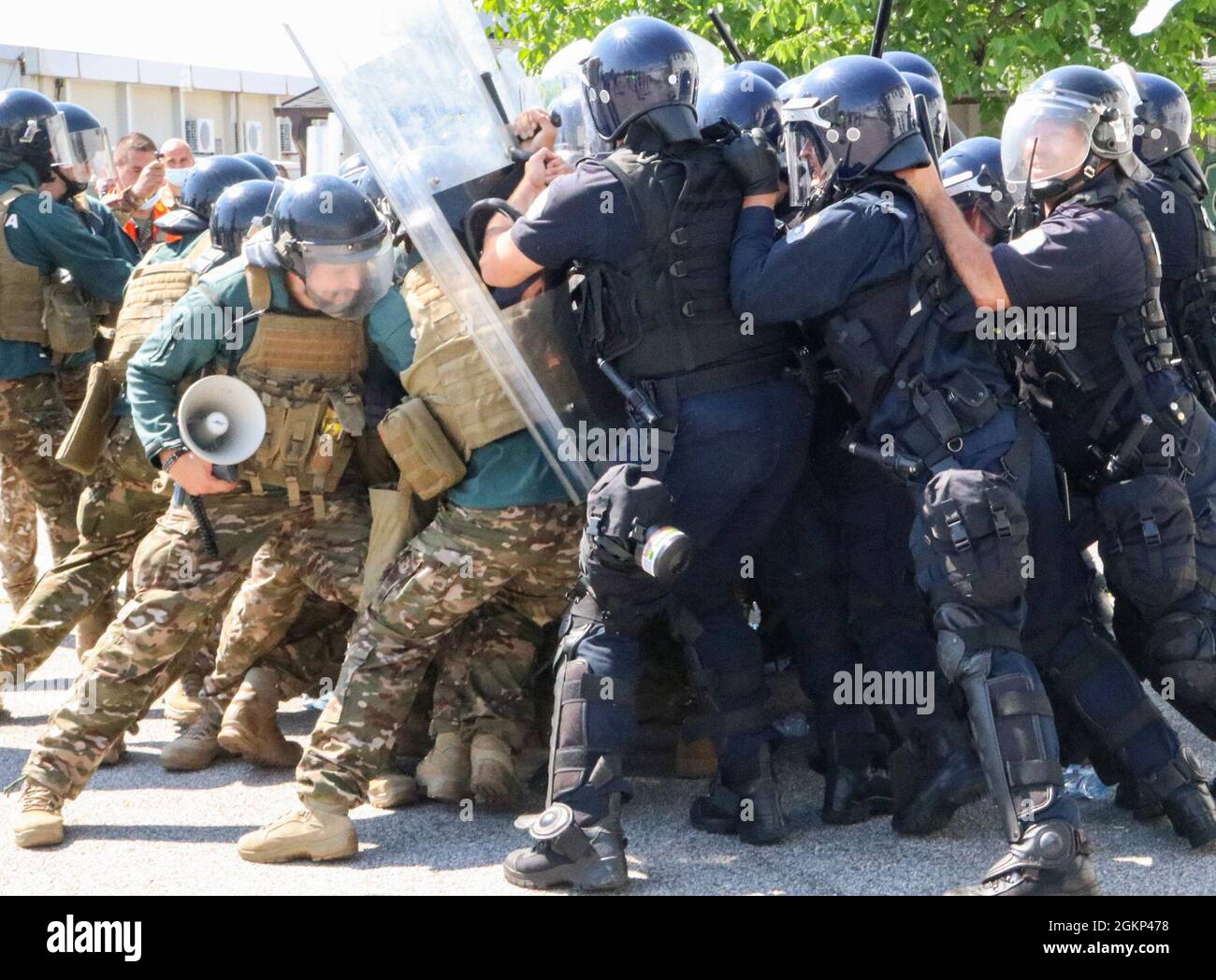 I soldati delle forze armate slovene si scontrano con gli ufficiali di polizia del Kosovo durante l'operazione Swift Rescue presso il campo aereo Gjakova/Gjakovë in Kosovo il 10 giugno 2021. L'operazione è stata la più complessa attività di formazione sul campo multinazionale condotta nella storia recente della forza del Kosovo. Le truppe slovene hanno svolto un ruolo di dimostranti civili durante l'esercizio, mentre i funzionari regionali del KP hanno risposto alle prime segnalazioni di un disturbo pubblico. Foto Stock