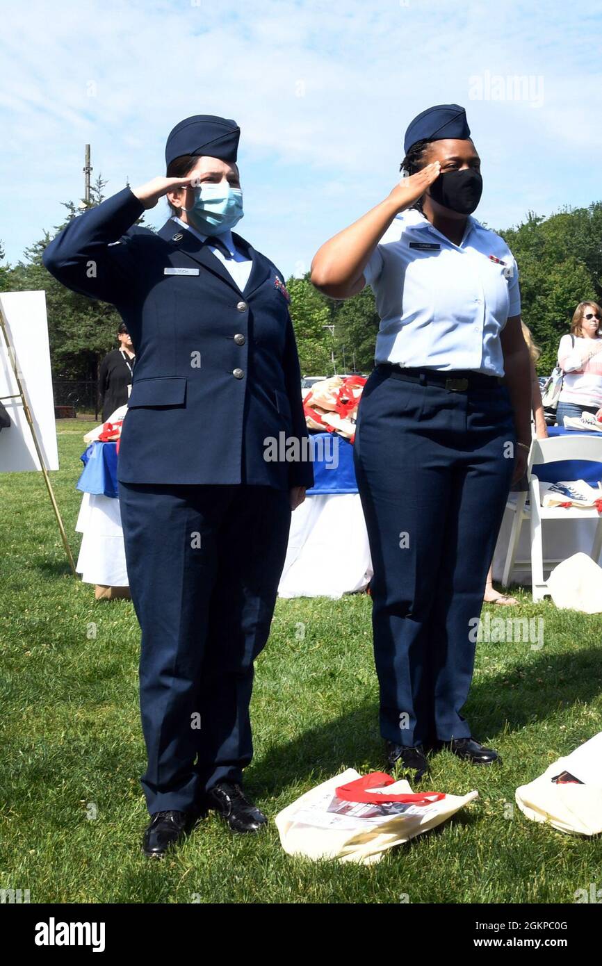 Personale Sgt. Siobhan Lynch, a sinistra, e Airman 1st Class Catera Turner salutano durante l’inno nazionale al 16° giorno annuale di apprezzamento dei Veterani delle Donne a Sharon, Mass., giugno 11. Katrina Stephens, comandante dell'installazione, II Lt. Stephanie Brushwood, Master Sgt. Sara Wright e TSgt. Christine Tuatoo ha partecipato alla cerimonia che ha riconosciuto le donne veterane del Massachusetts. Foto Stock
