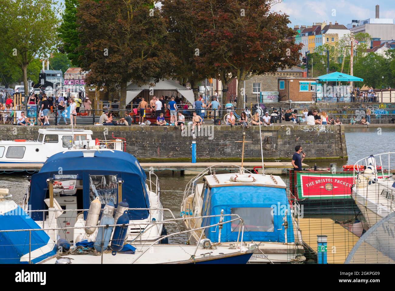 Bristol UK Waterfront, vista in estate dei giovani che si rilassano nella zona di Harbourside nel centro di Bristol, Inghilterra, Regno Unito Foto Stock