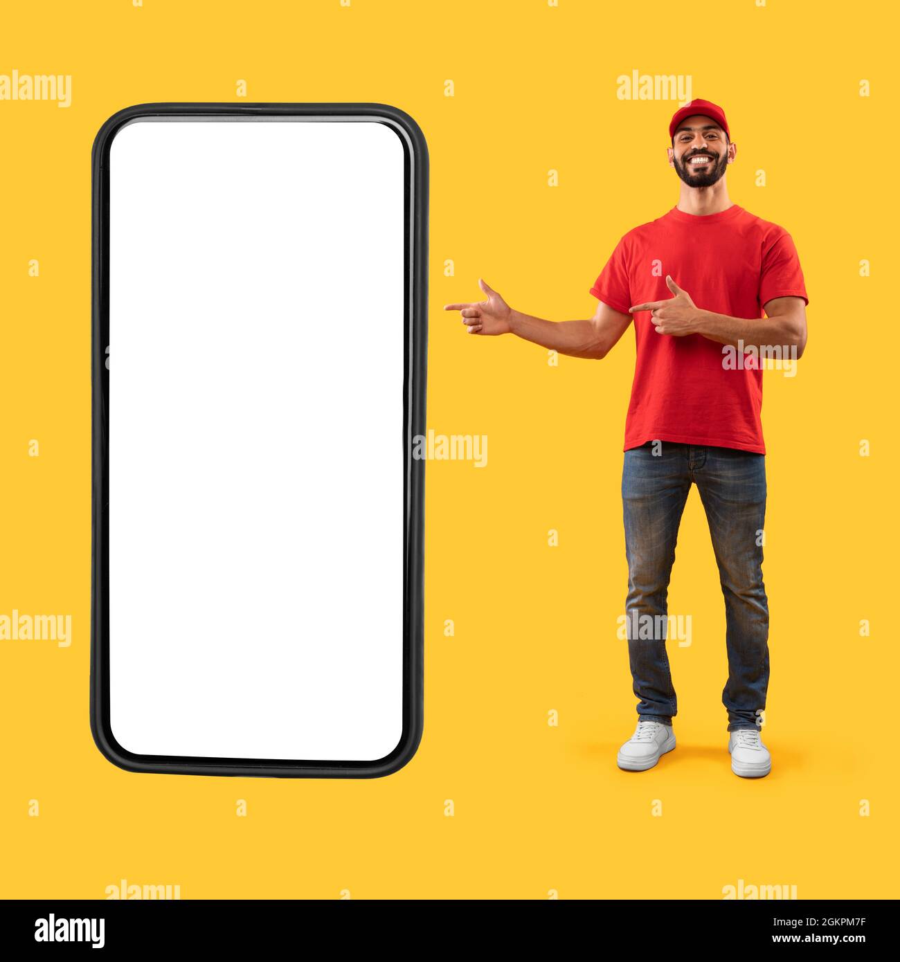 Utente di consegna arabo che mostra enorme schermo del telefono su sfondo giallo Foto Stock