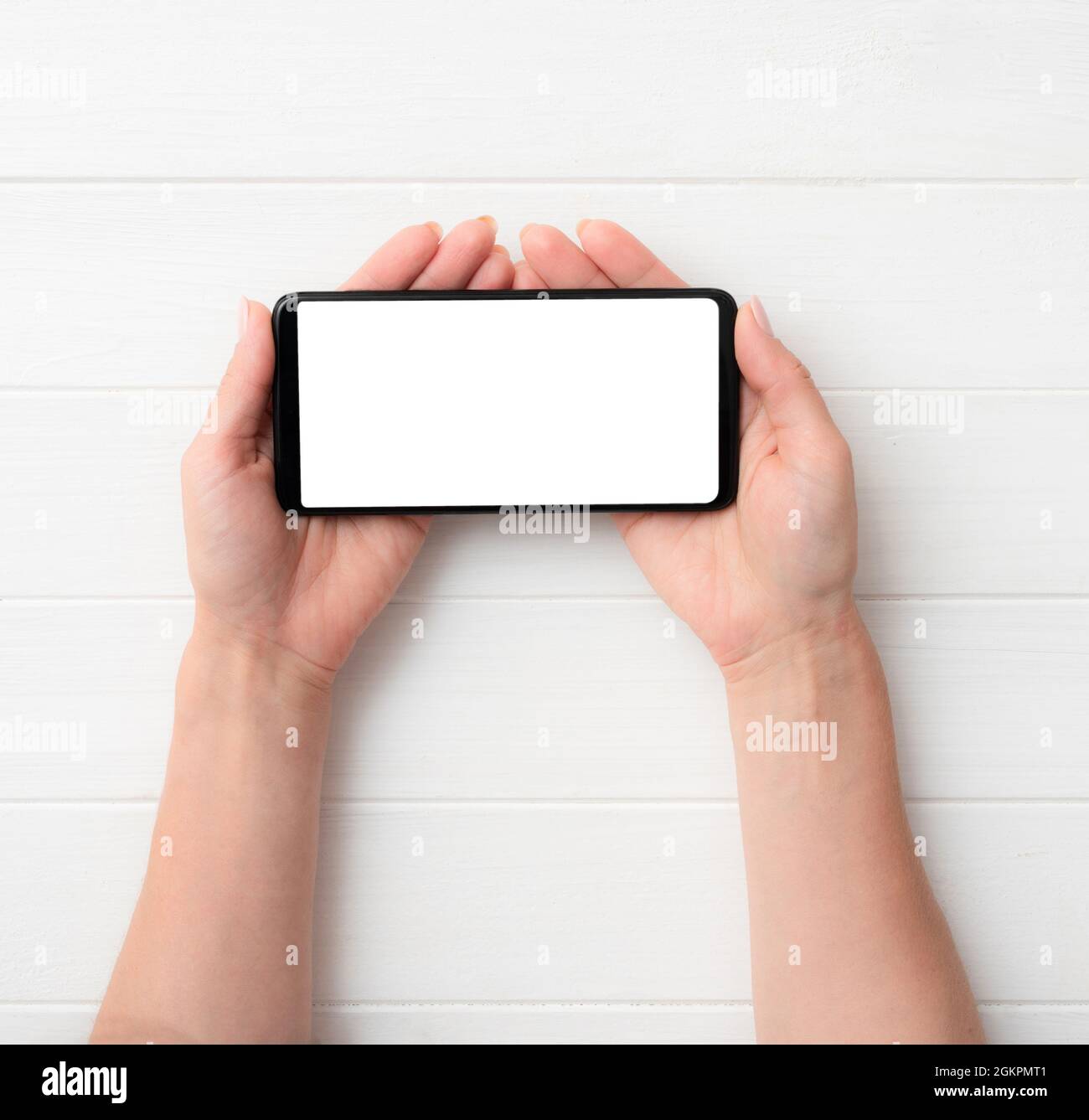 Smartphone nero con schermo bianco nelle mani Foto Stock