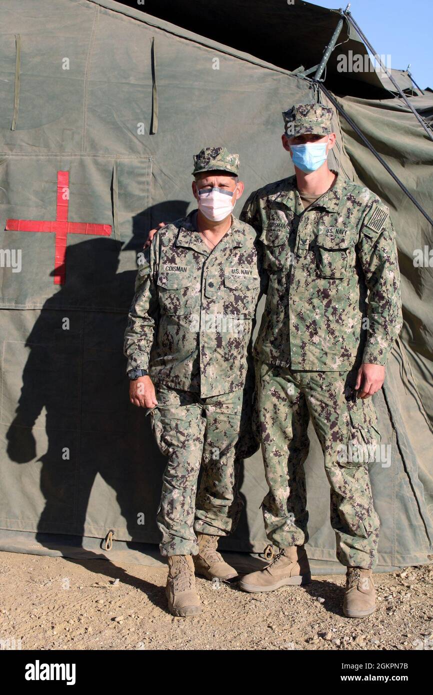 CMdR. Rob Coisman e suo figlio, Hospital Corpsman III Classe Matthew Coisman, si fermano fuori da un ospedale da campo a Fort Hunter Liggett, California, durante l'esercizio medico globale 2021. I marinai sono attaccati a una struttura medica della Marina Reserve Expeditionary che partecipa a Global Medic, un esercizio di formazione sul campo di più giorni basato su forze congiunte che simula lo spiegamento di combattimenti nel mondo reale in un ambiente austero. Il comando di formazione sulla preparazione medica esegue la medicina globale come parte della più grande missione del comando medico della Riserva dell'esercito per fornire unità addestrate, attrezzate e combattenti pronte e personale medico per fare il sup Foto Stock