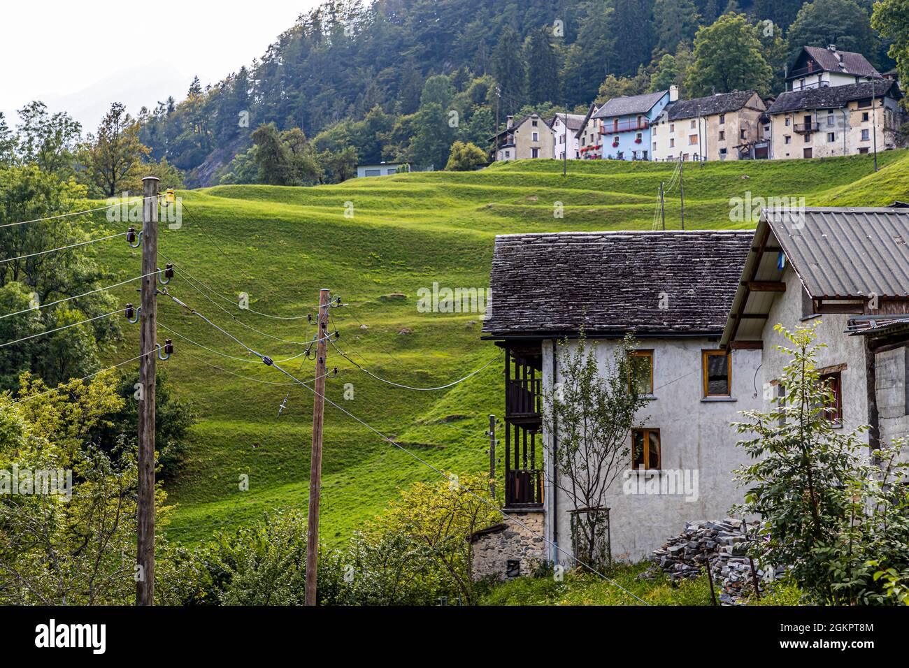 A Cerentino, i visitatori possono soggiornare nella storica casa patrizia Cà Vegia, finemente ristrutturata, con mobili secolari ma senza elettricità. Dietro la casa si trovano le linee elettriche che forniscono elettricità alle altre case del paese, Circolo della Rovana, Svizzera Foto Stock