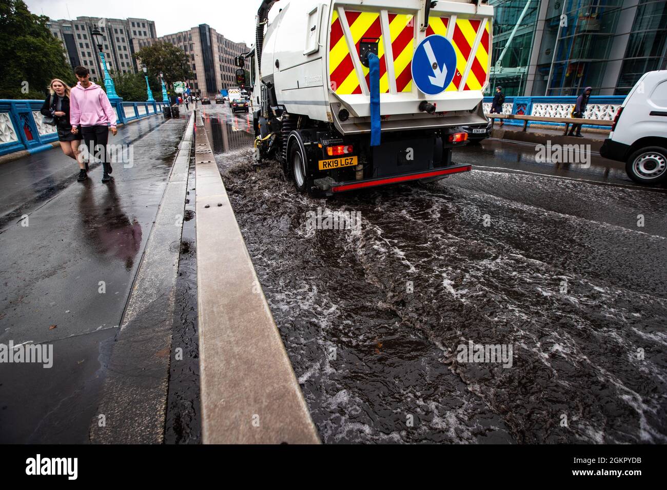 Un veicolo di manutenzione utilizza una pompa a vuoto per aspirare l'acqua di alluvione sul Tower Bridge. Foto Stock