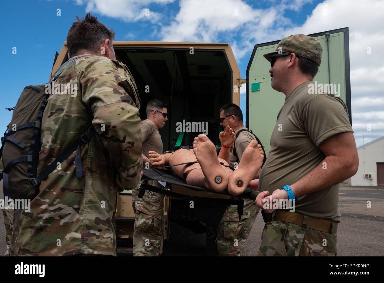 I membri del 152° gruppo medico distaccamento 1 chimico, biologico, radiologico, nucleare ed esplosivo ad alto rendimento (CBRNE) Enhanced Response Force Package (CERFP) caricano un paziente simulato in un'ambulanza a Kapolei, Hawaii, 16 giugno 2021. L'ambulanza ha la capacità di avere quattro pazienti caricati nella zona posteriore alla volta. Foto Stock