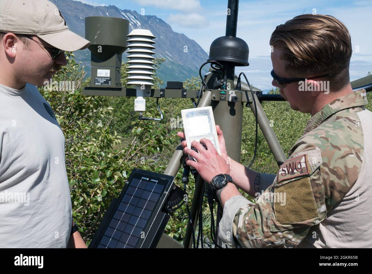 U.S. Air Force Tech. SGT. J.B. Sexson, il terzo responsabile non commissionato dell’operazione meteorologica di Operations Support Squadron, spiega un sistema di osservazione meteorologica tattica a Senior Airman Collin Stock, a Survival, Evasion, Resistance, E Escape Specialist assegnato al 66° Squadrone di addestramento, distaccamento 1, a supporto di operazione Colony Glacier in un remoto posto di osservazione meteo vicino Colony Glacier, Alaska, 17 giugno 2021. Operazione Colony Glacier è uno sforzo per recuperare i resti dei membri di servizio e il relitto da un aereo C-124 che crash atterrò nel novembre 1952 Foto Stock