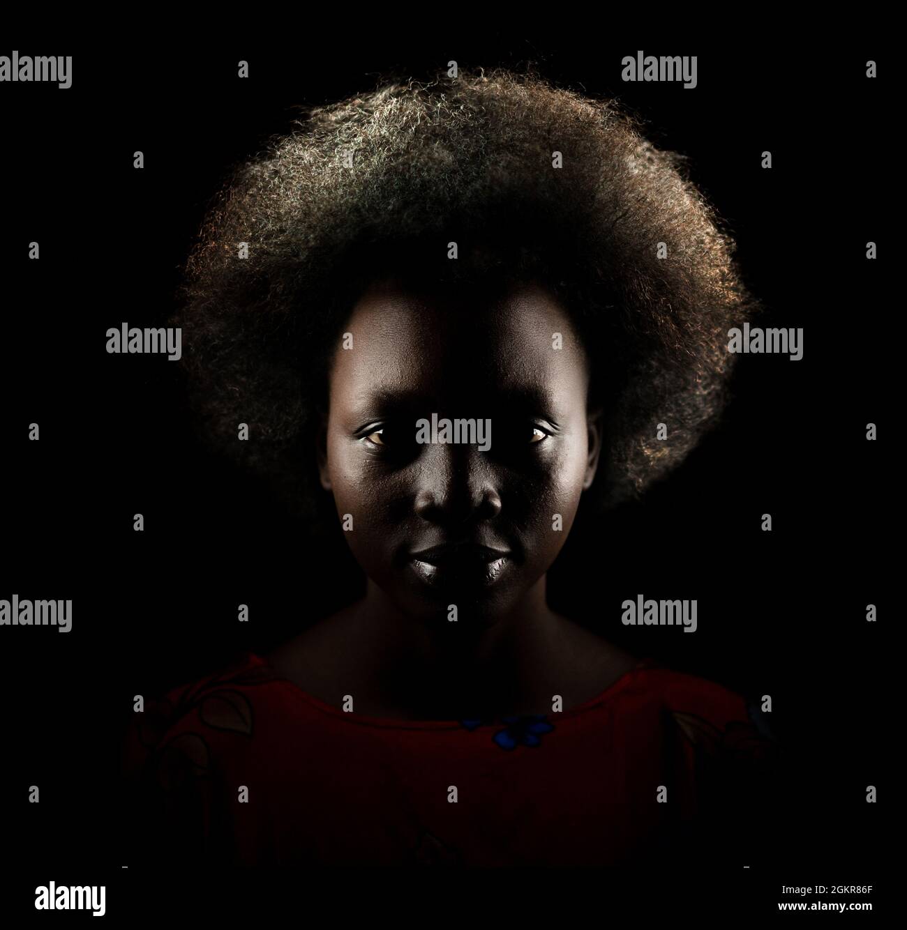 Ritratto scuro di giovane donna nera con capelli afro stile Foto Stock
