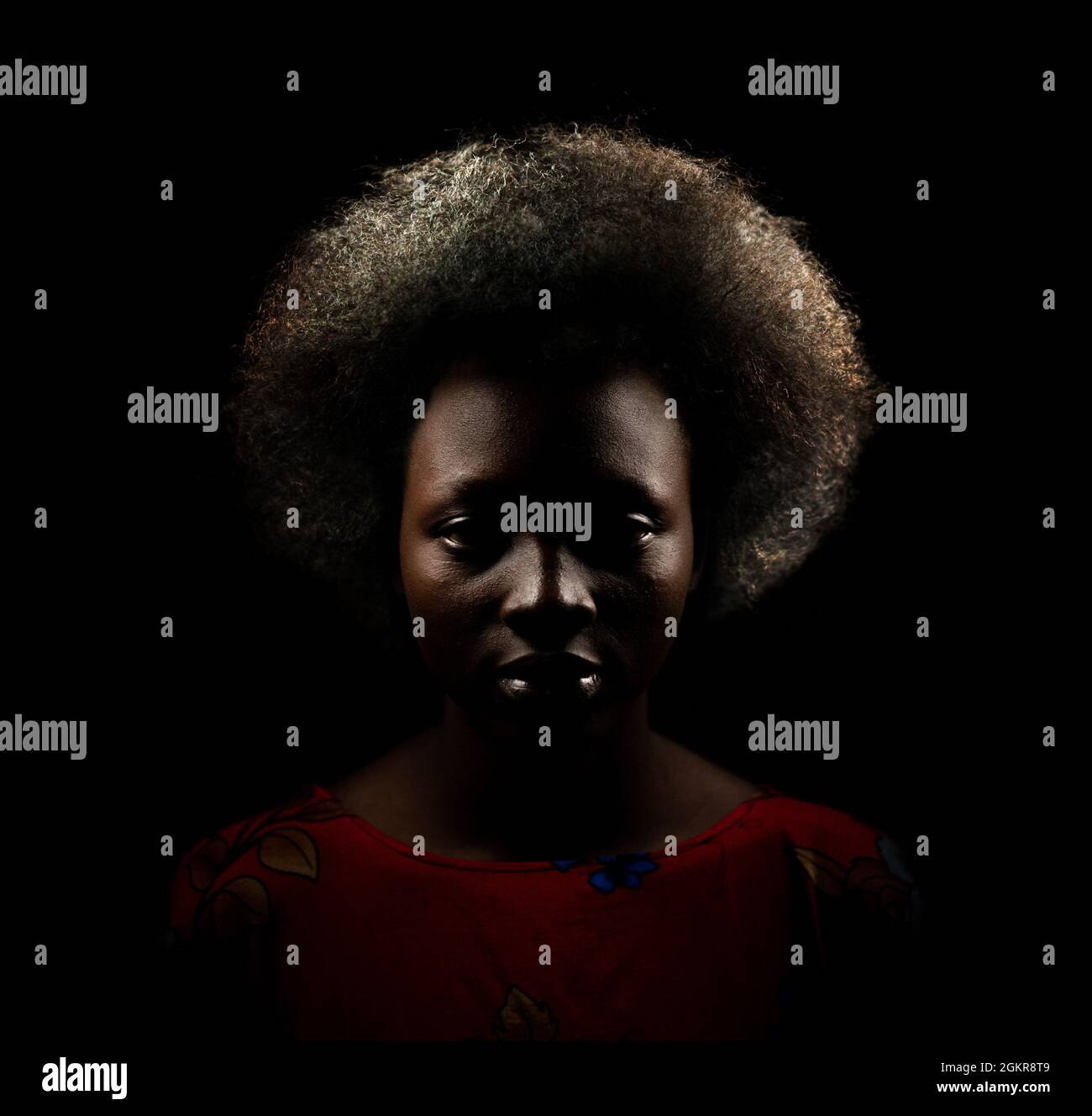 Ritratto scuro di giovane donna nera con capelli afro stile Foto Stock