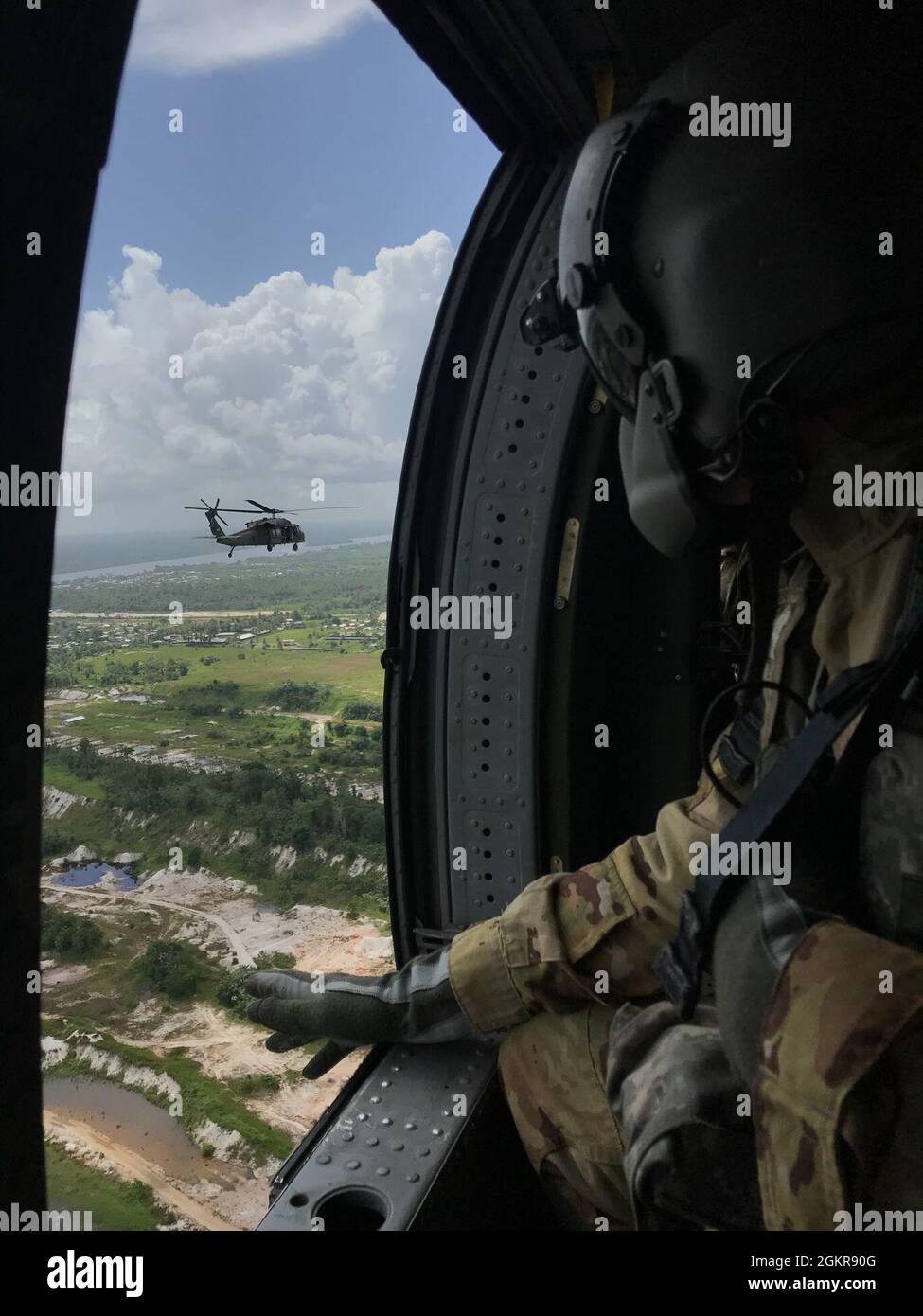 210618-N-FB085-002 Guyana (18 giugno 2021) - SPC. Nicholas Wood con la Guardia Nazionale della Florida 1-185th Assault Helicopter Battaglione scansiona la campagna della Guyana durante un volo in un UH-60 Blackhawk, 18 giugno 2021 durante l'esercizio Tradewinds. Tradewinds 2021 è un esercizio multidimensionale incentrato sulla sicurezza dei Caraibi condotto nei domini terra, aria, mare e cyber. Le forze degli Stati Uniti si uniscono alle nazioni partecipanti per condurre una formazione congiunta, combinata e interagenzia focalizzata sull'aumento della cooperazione regionale in complesse operazioni di sicurezza multinazionali. Foto Stock