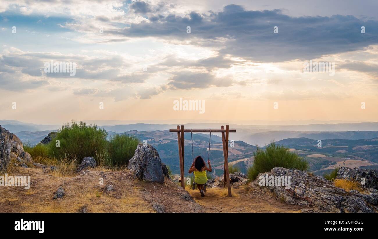 Mogadouro, Portogallo - 26 agosto 2021 : Woman Swinging in cima alla montagna, Distretto di Braganca, Portogallo Foto Stock