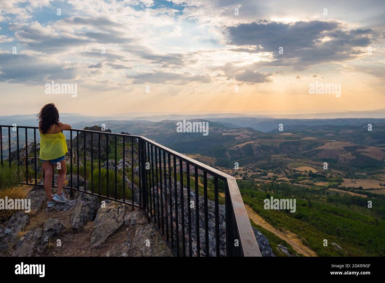 Mogadouro, Portogallo - 26 agosto 2021 : Donna che si gode il tramonto dalla cima della montagna., Distretto di Braganca, Portogallo Foto Stock