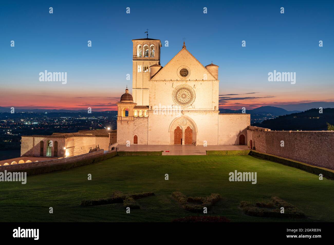 Facciata della Basilica di San Francesco d'Assisi, patrimonio dell'umanità dell'UNESCO, e giardini al tramonto, Assisi, provincia di Perugia, Umbria, Italia, Europa Foto Stock