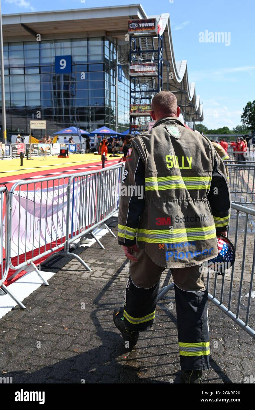 Master Sgt. Sean Sullivan, assistente capo della formazione nel 445esimo Squadrone Ingegnere civile, torna nell'area di possesso dell'atleta per mettere a disposizione le sue attrezzature protettive dopo il completamento del corso finale al FireFit Europe Championships il 20 giugno. Ha completato il percorso a sei ostacoli, che includeva il trasporto di 45 libbre di marcia su cinque rampe di scale, in meno di 90 secondi, mentre indossava l'attrezzatura di regolazione con un serbatoio di ossigeno e maschera. Le temperature diurne ad Hannover, Germania, sono salite agli anni '80 durante la competizione di più giorni. Foto Stock