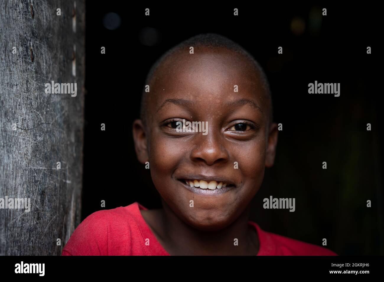 Ritratto africano del ragazzo nero in piedi vicino alla sua povera casa da solo Foto Stock